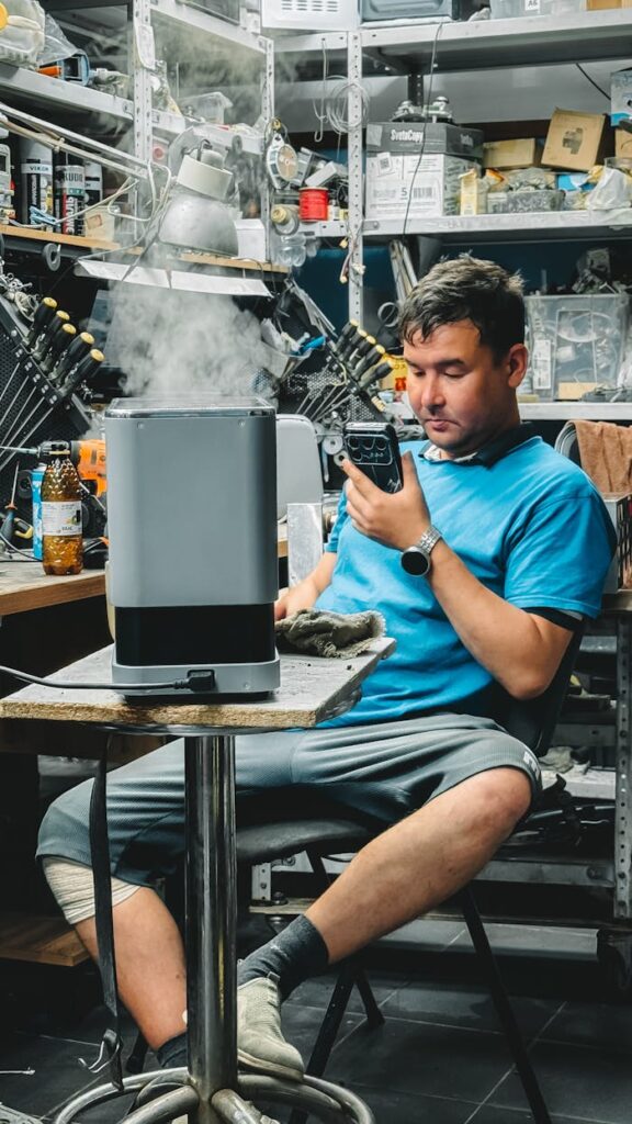 Young man in workshop using vintage equipment, surrounded by tools and smoke.